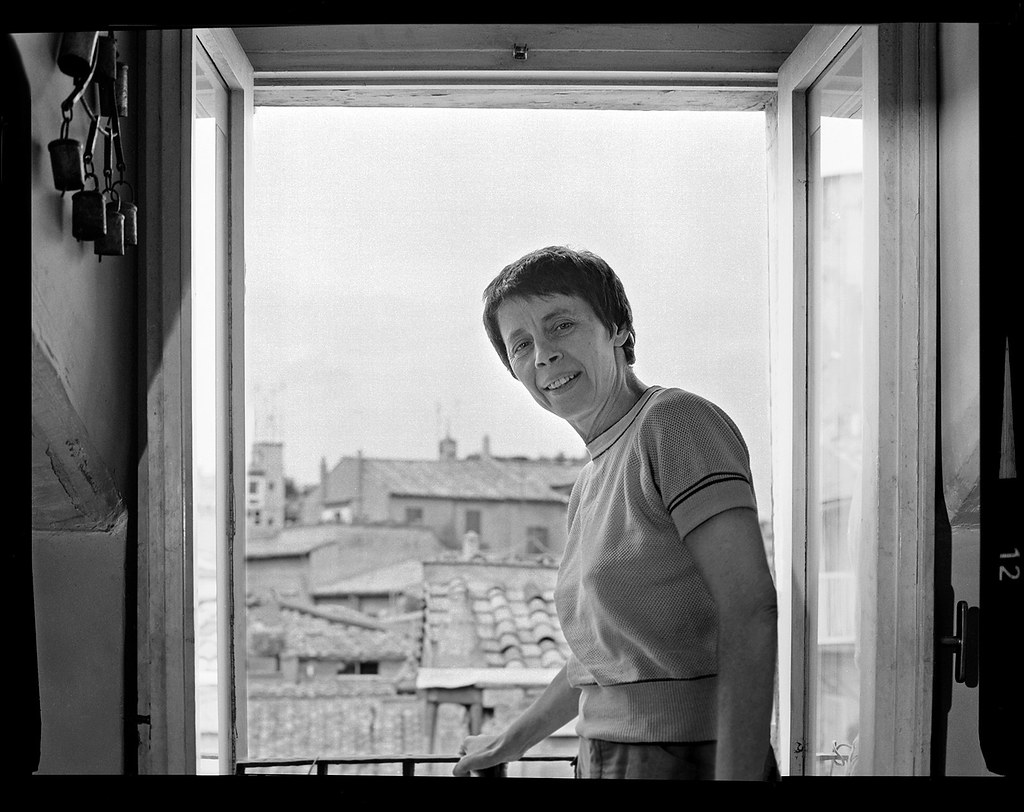 Amelia Rosselli fotografata da Dino Ignani davanti a una finestra aperta.