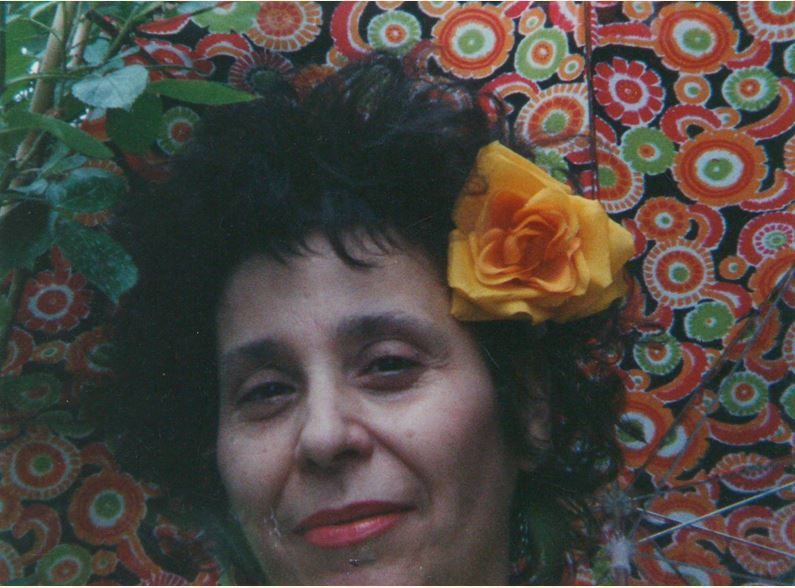 Ritratto in primissimo piano di Maria Grazia Lenisa con una rosa gialla tra i capelli